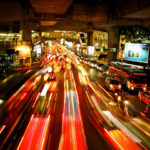 Traffic moving at night, with blurred traced lights indicating motion