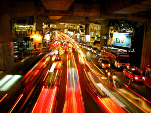 Traffic moving at night, with blurred traced lights indicating motion